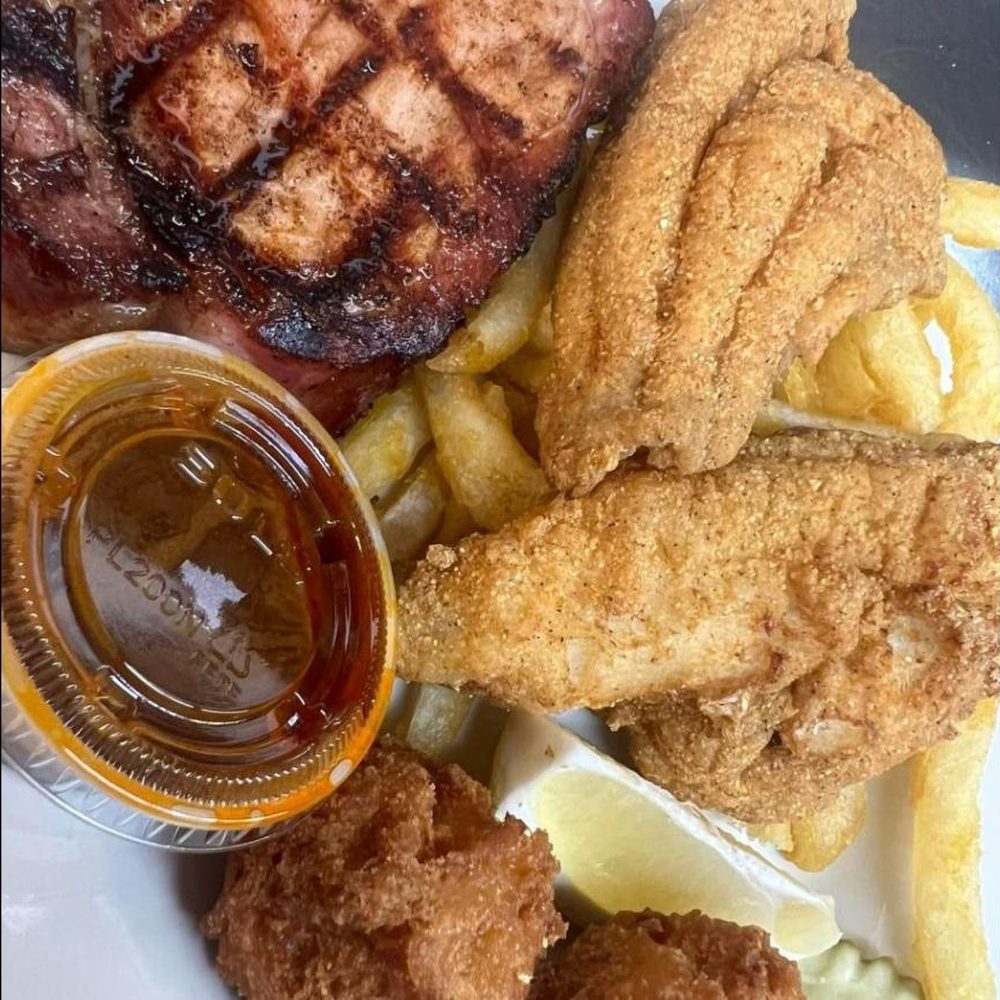 Fried catfish filets and a smoked pork chop with fries