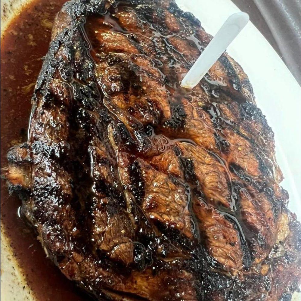 Charbroiled ribeye steak resting in its juices