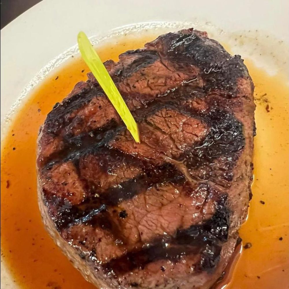 Thick ribeye cooked medium on a white plate